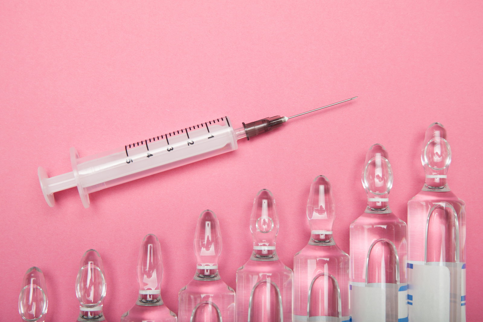 Increasing dependence on injections of hyaluronic acid botox an | Live That Glow Increasing dependence on injections of hyaluronic acid, botox and collagen. Syringe and ampoules on a pink background.