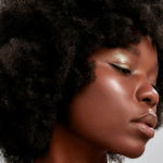 Woman with a dark skin tone showing how to pick the perfect blusher hair