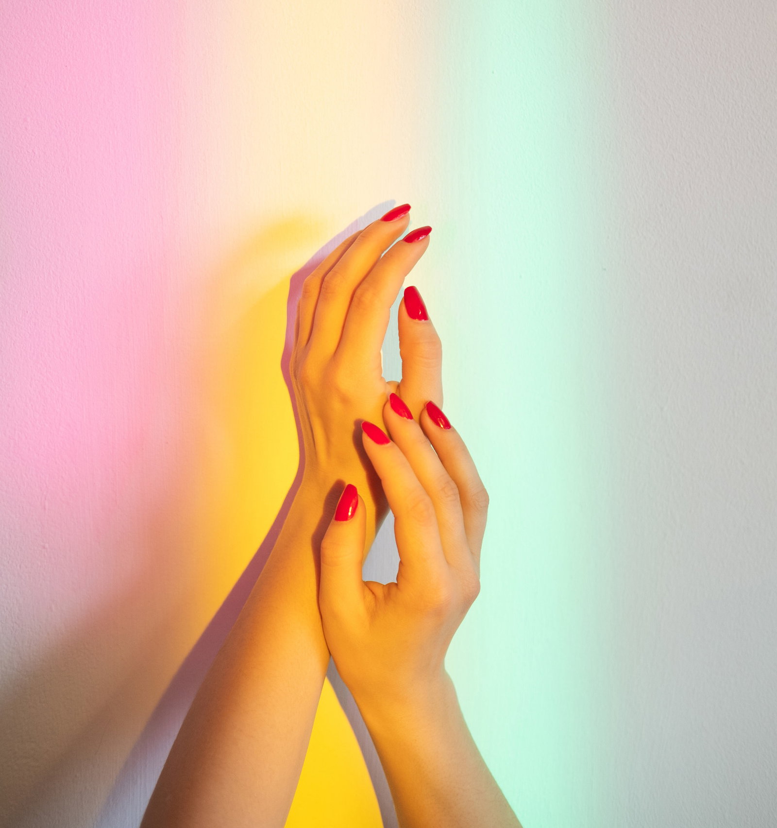 smooth skin care treatment protection moisturizing | Live That Glow Smooth skin care. Treatment protection. Moisturizing nutrition. Neil beauty salon. Female hands with red polish tenderly holding together on wall blur rainbow overlay glowing lights. how to remove acrylic nails at home