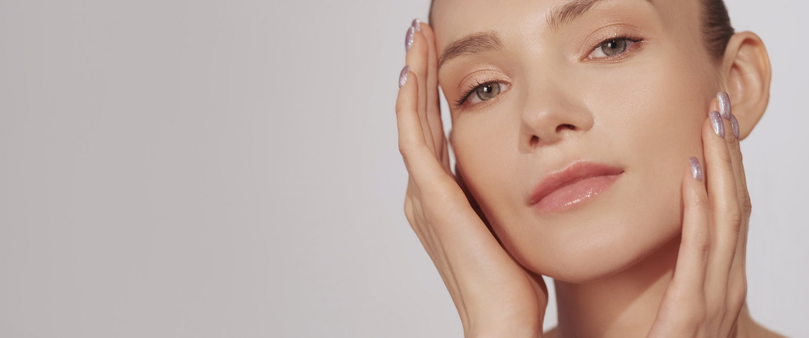 Skin moisturizing facial care woman touching face | Live That Glow Skin moisturizing. Facial care. Beauty wellness. Woman with nude makeup enjoying touching soft radiant face isolated on beige background empty space. Botox