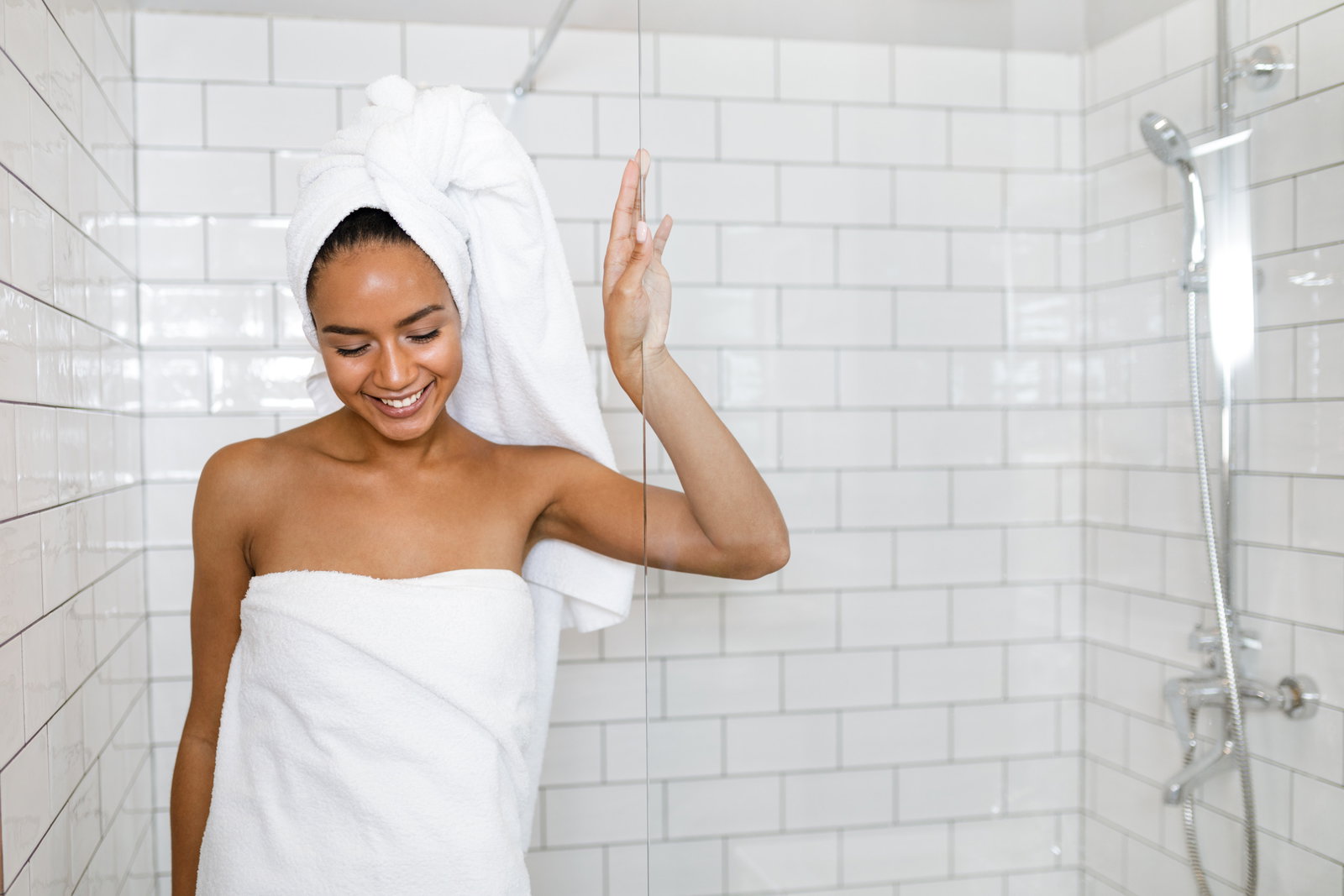 Young woman in white towels wrapped around head and body after shower | Live That Glow