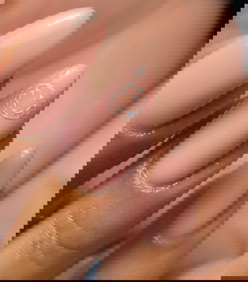 nude almond nails with 90s silver smiley faces