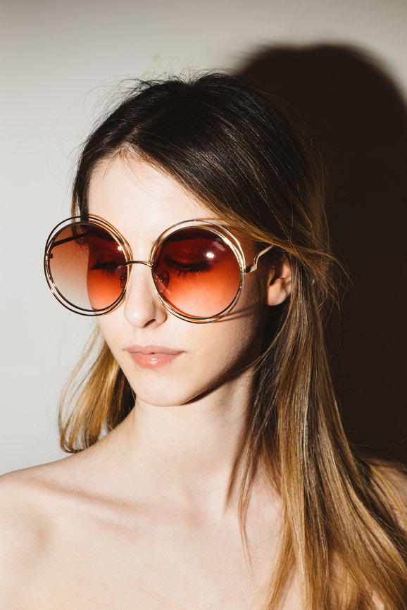 Portrait of a pretty young woman with long hair and retro sunglasses | Live That Glow