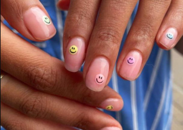 sheer pink nails with pastel smiley faces