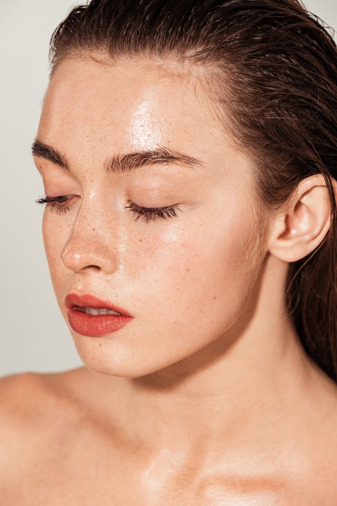 beautiful girl with coral lips and wet skin posing isolated on grey | Live That Glow bridal makeup