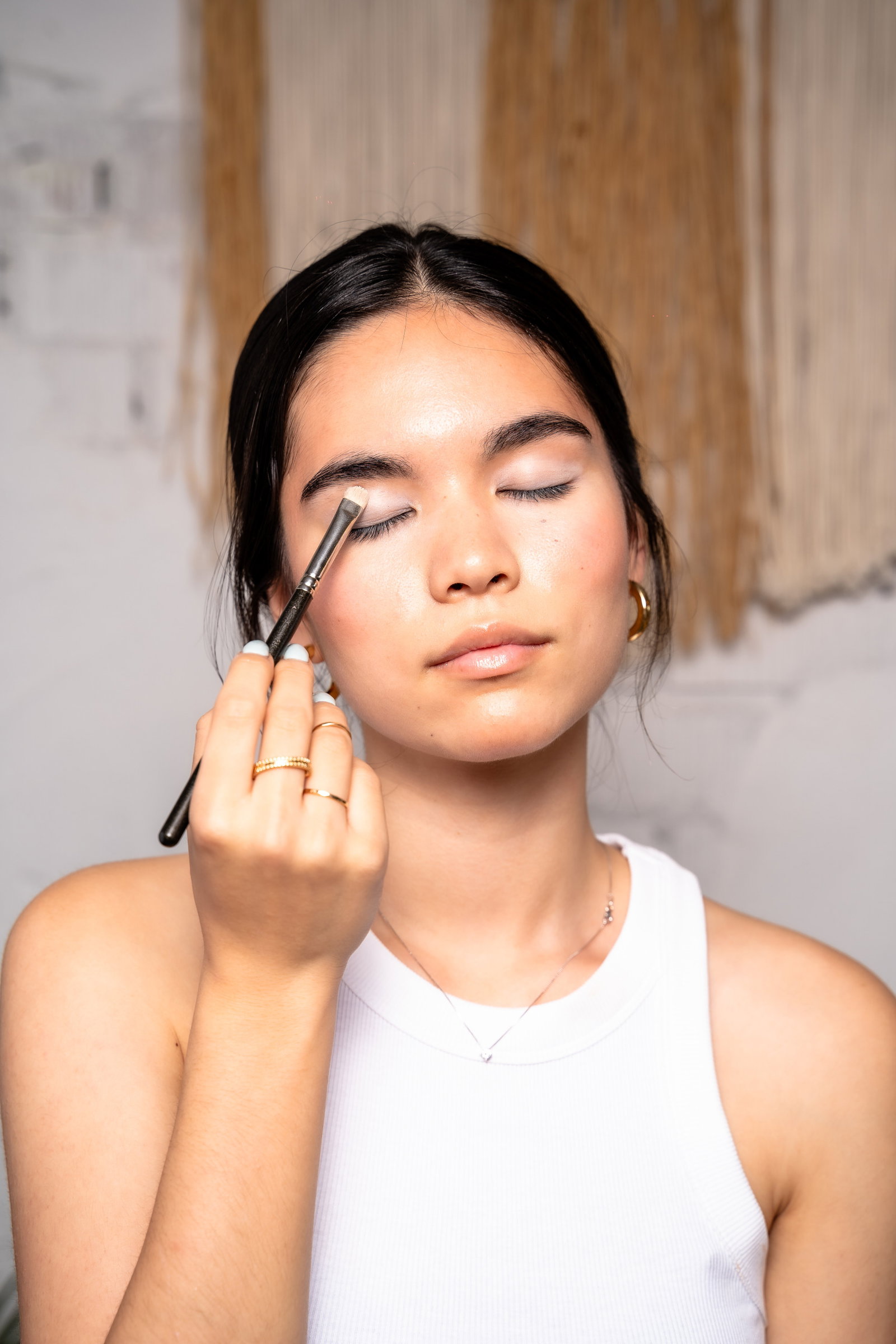 Girl showing how to apply makeup primer before doing a smokey eye look