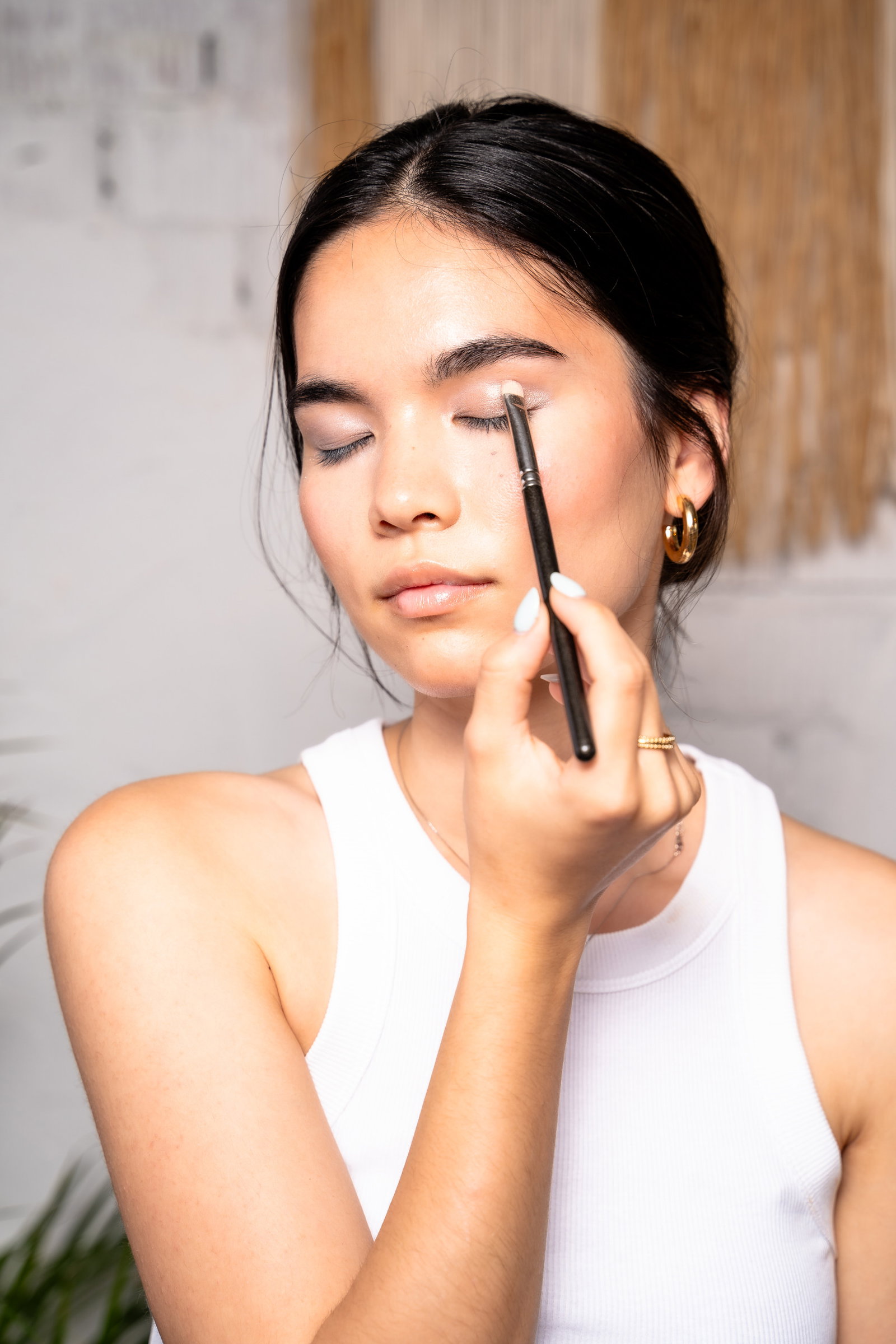 Girl showing how to apply base colour in a smokey eye look