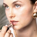 Woman showing how to apply lipstick