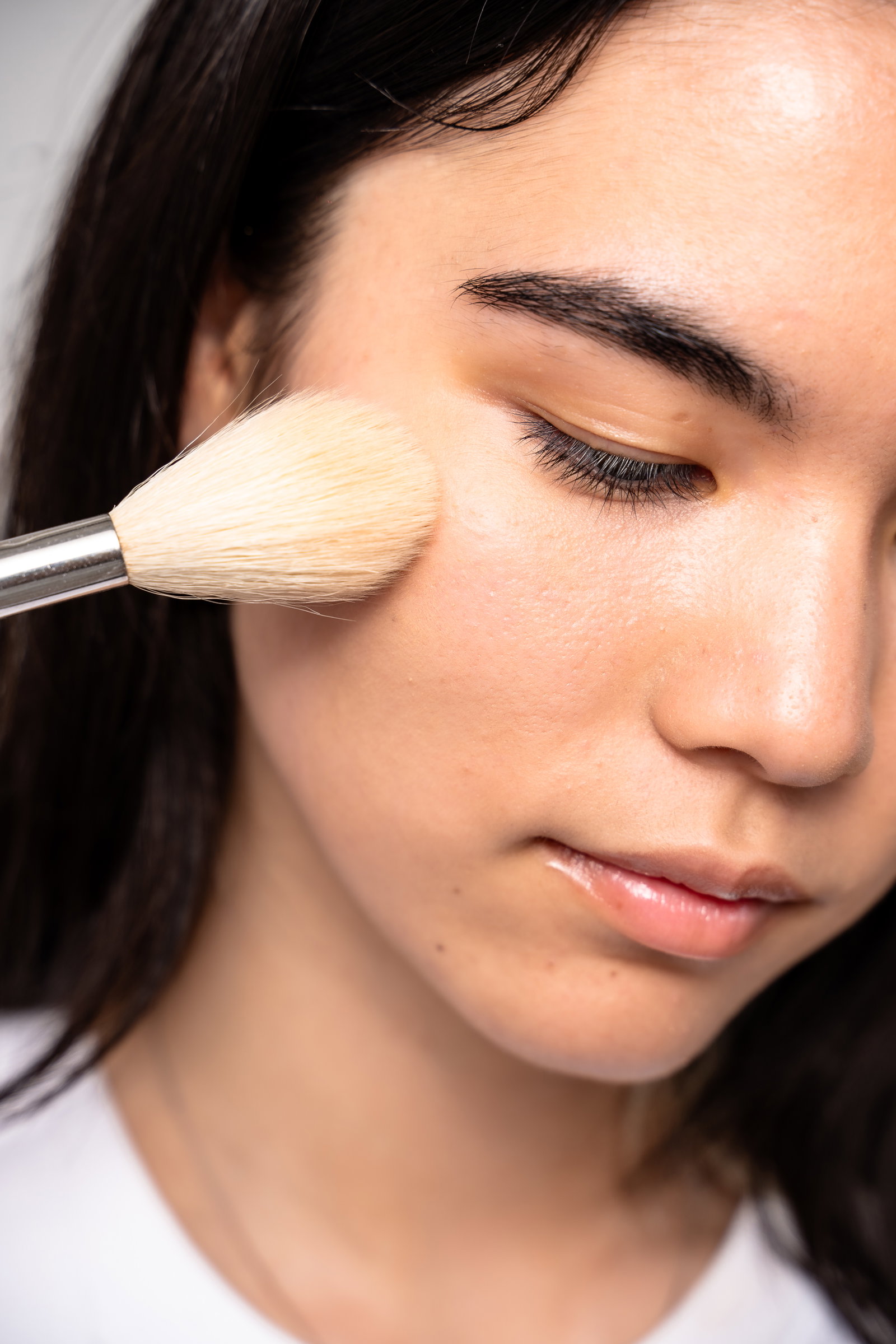 Image of girl showing how to apply makeup powder to under eyes