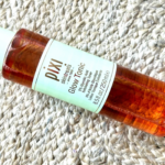 Pixi Glow Tonic 5% glycolic acid exfoliating toner bottle lying on a woven rug