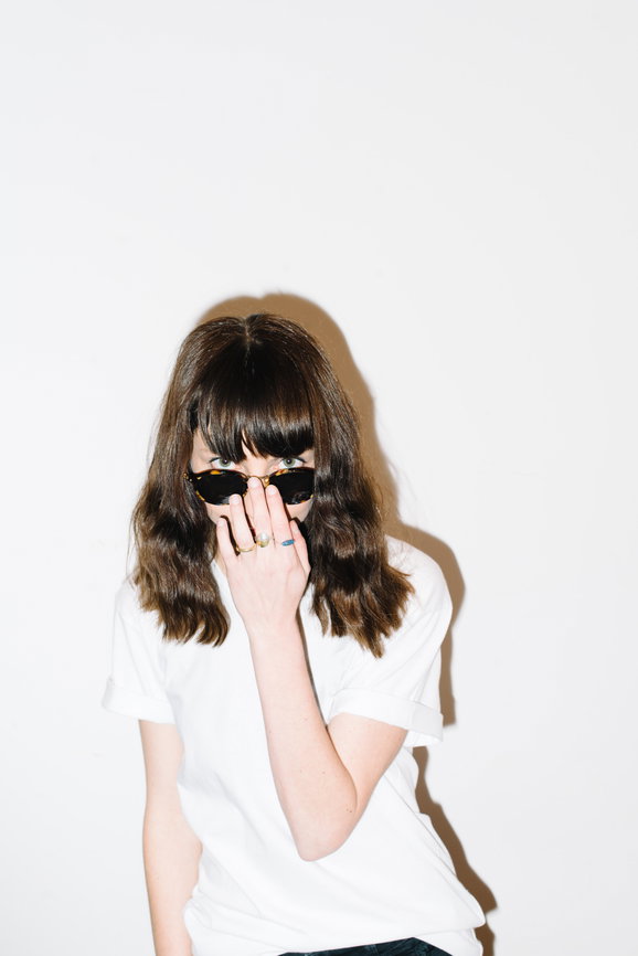 A woman posing against a white backdrop | Live That Glow