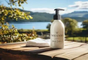 Cream pump bottle of MO&YO conditioner on a wooden table outdoors by a lake, with mountains in the background.