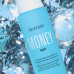 Blue Color Wow Money Mist spray bottle among sparkling blue crystal-like shapes, conveying a hair product advertisement