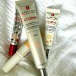 Several Erborian skincare tubes (CC Cream and BB Cream) lying on a white fabric surface on a towel-like cloth.
