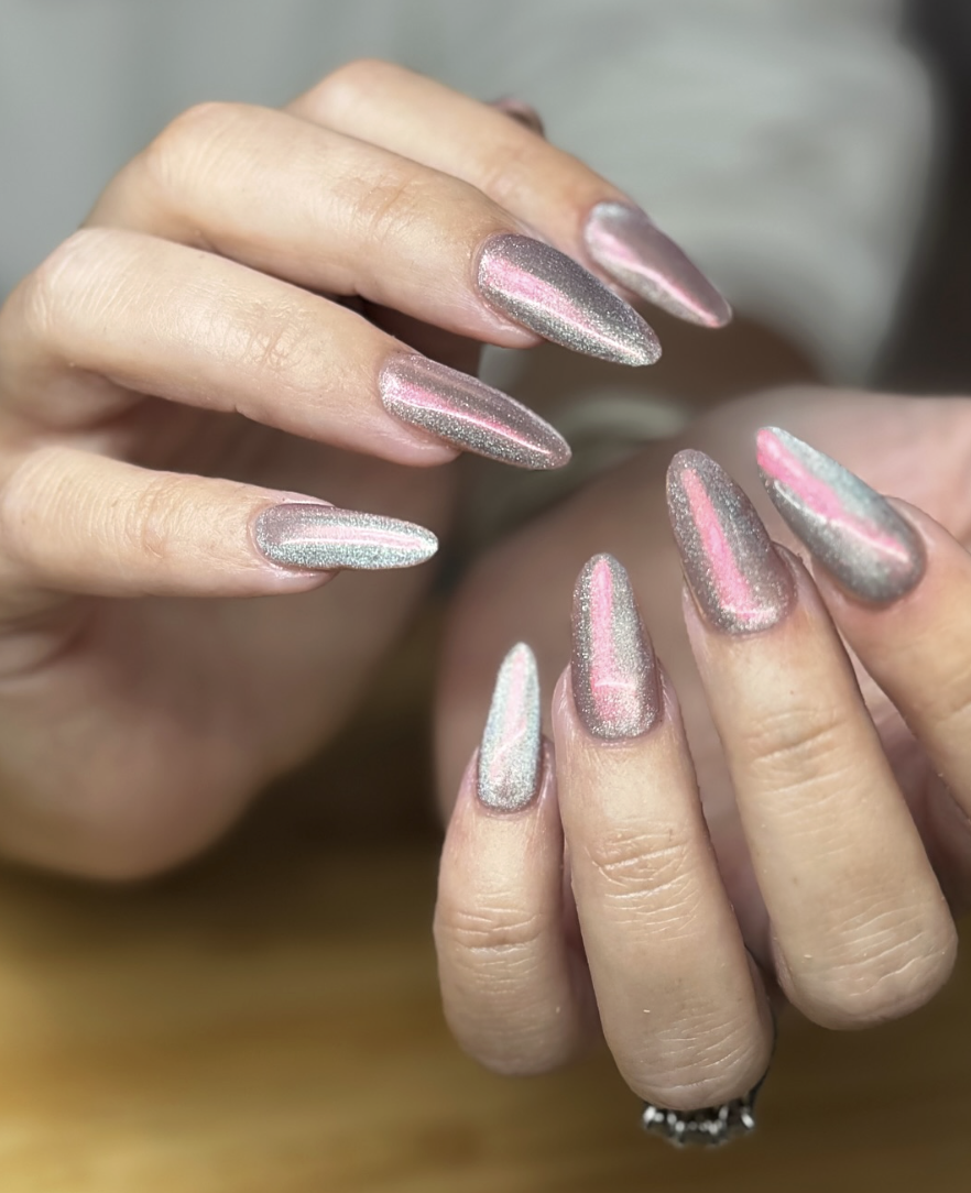 Manicured nails with metallic silver-pink gradient and almond shape, close-up view of fingernails with shimmery polish