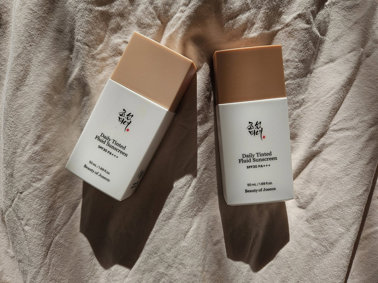 Beauty of Joseon Daily Tinted Fluid Sunscreen SPF 30 bottles showing two different tint shades