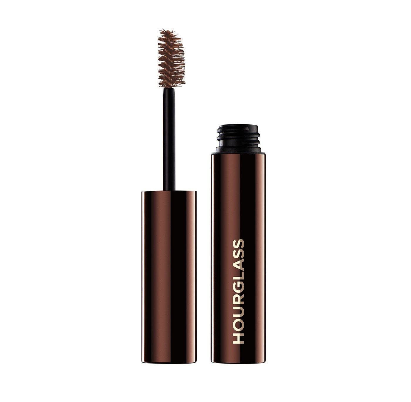 Brown mascara tube with wand brush beside it on a white background, brand visible on the tube edge.