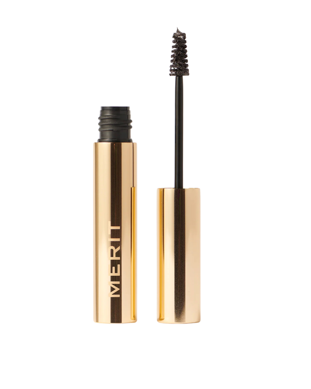 Gold mascara tube with wand lifted, labeled MERIT, ready to apply to lashes.