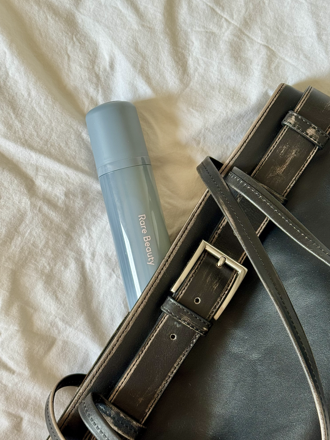 rare-beauty-find-comfort-body-hair-mist | Live That Glow Rare Beauty Find Comfort Body & Hair Fragrance Mist beside a black handbag