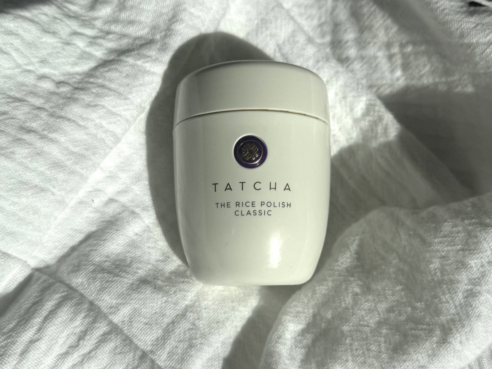 Tatcha The Rice Polish Classic photographed on white fabric for our review