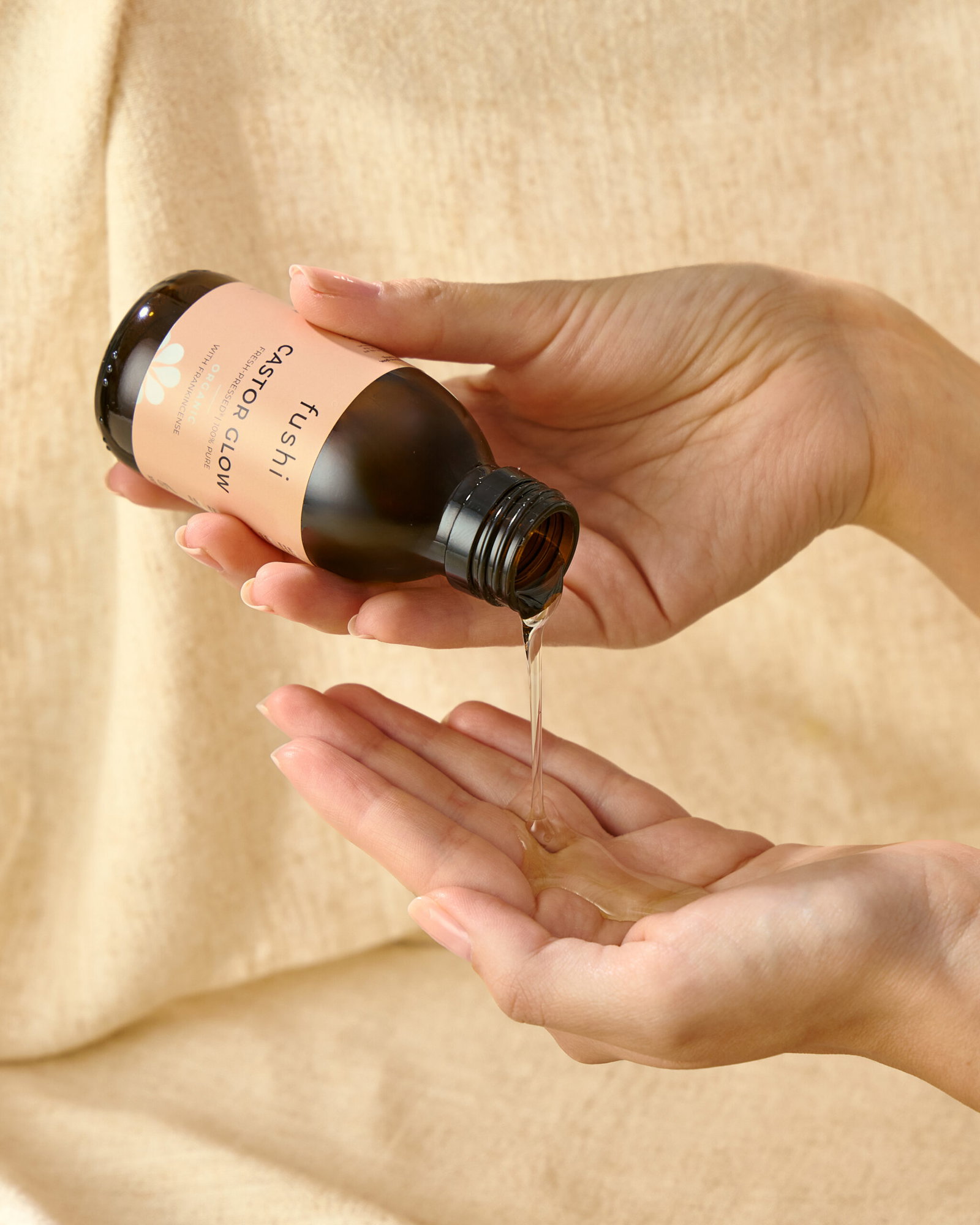 Fushi Castor Glow oil being poured into a person's hand