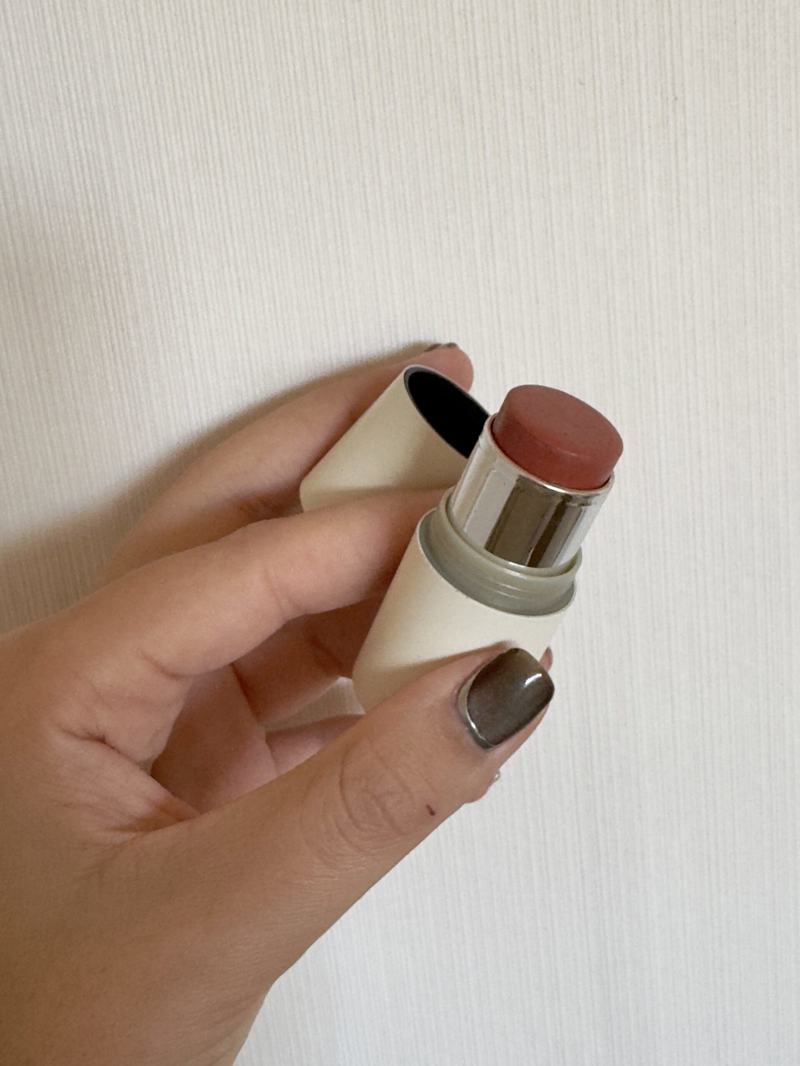 ILIA Multi-Stick cream blush held in hand with the cap removed