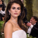 Kaia Gerber wearing her long brunette hair in a smooth, glossy blowout