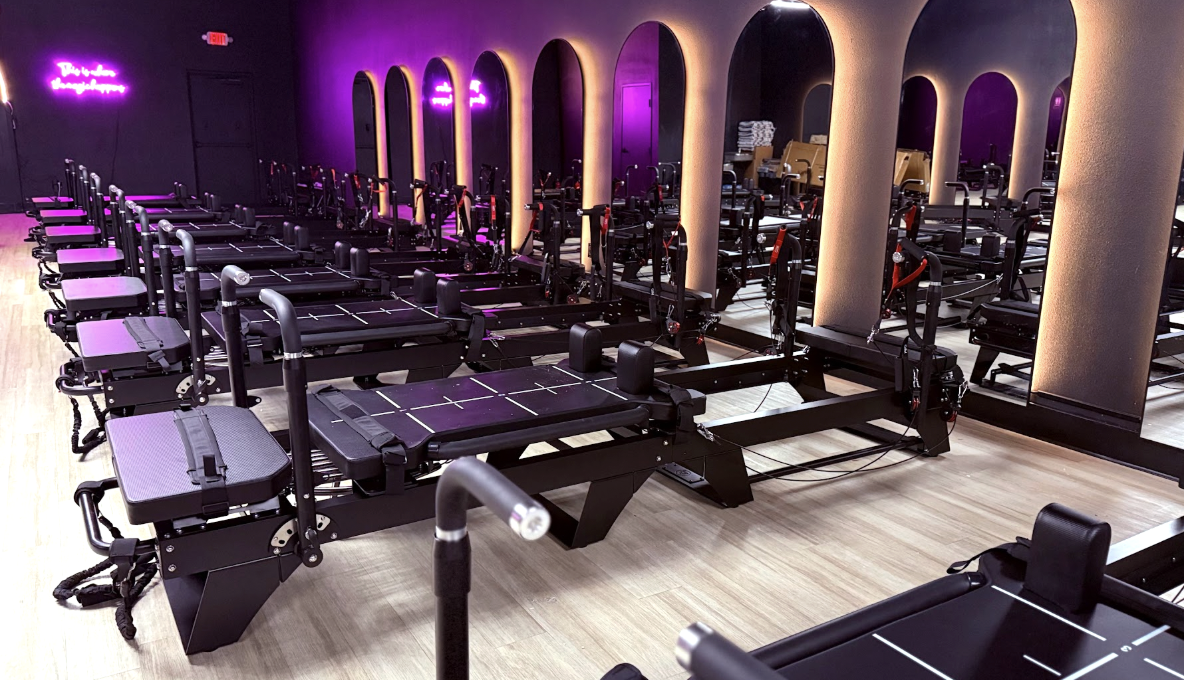Lagree workout studio with rows of resistance training machines