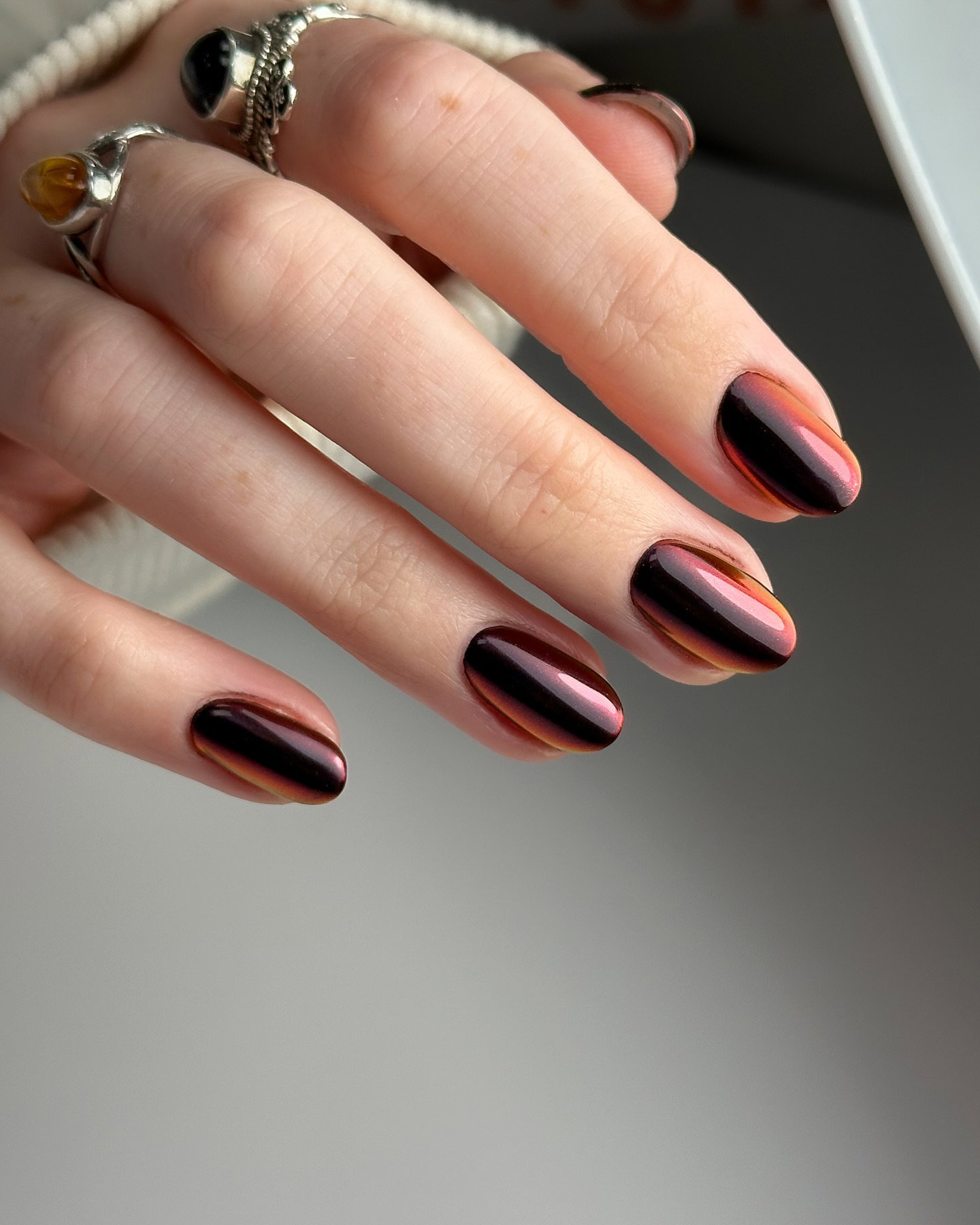 Burgundy cat-eye nails with a reflective magnetic finish.