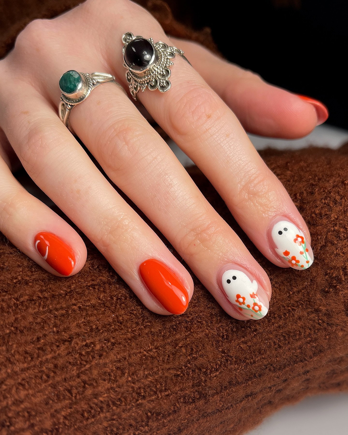 Orange Halloween nails with cute white ghost and floral nail art.