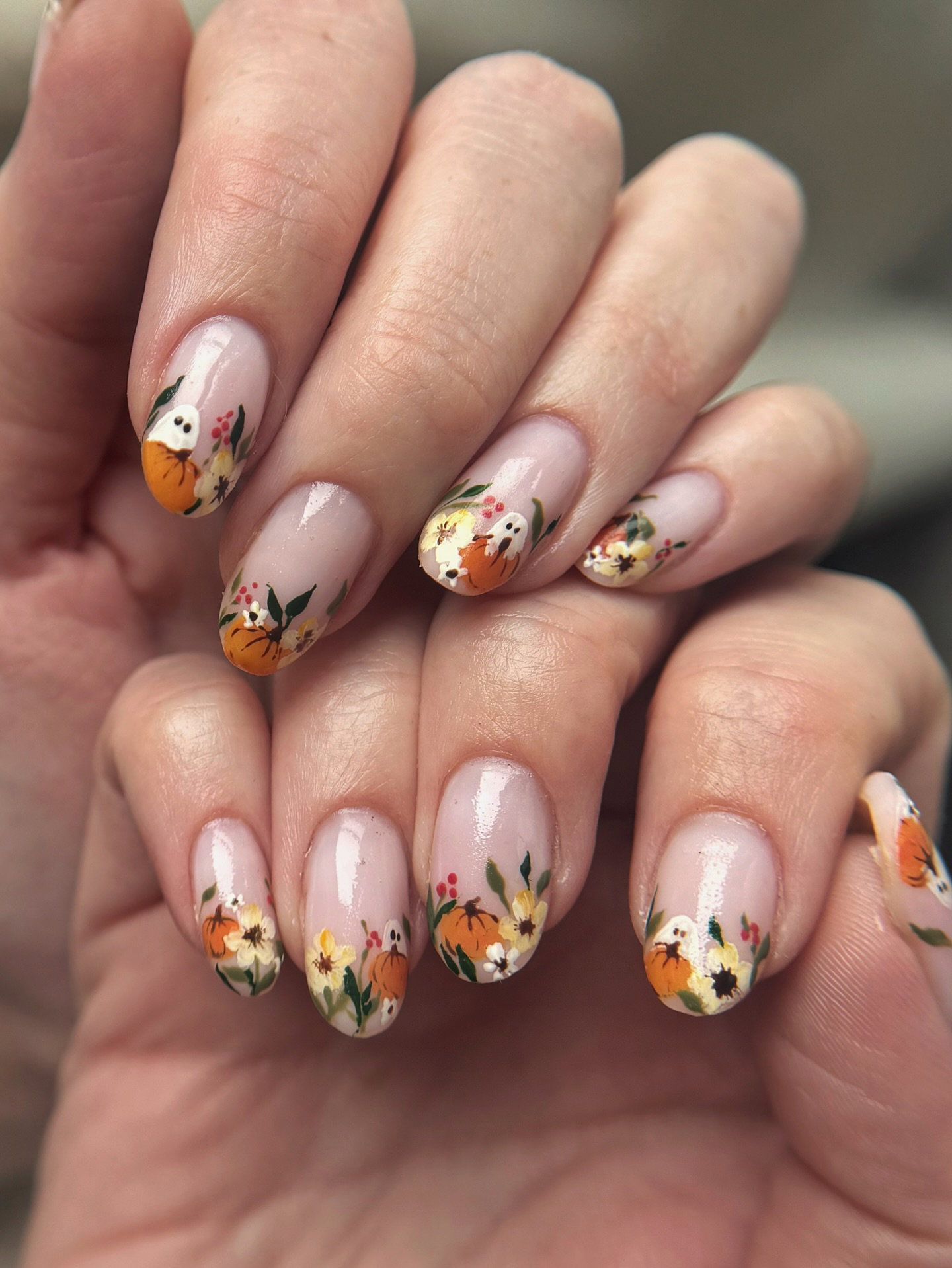 Autumn floral nails with tiny pumpkins, flowers and white ghost nail art.