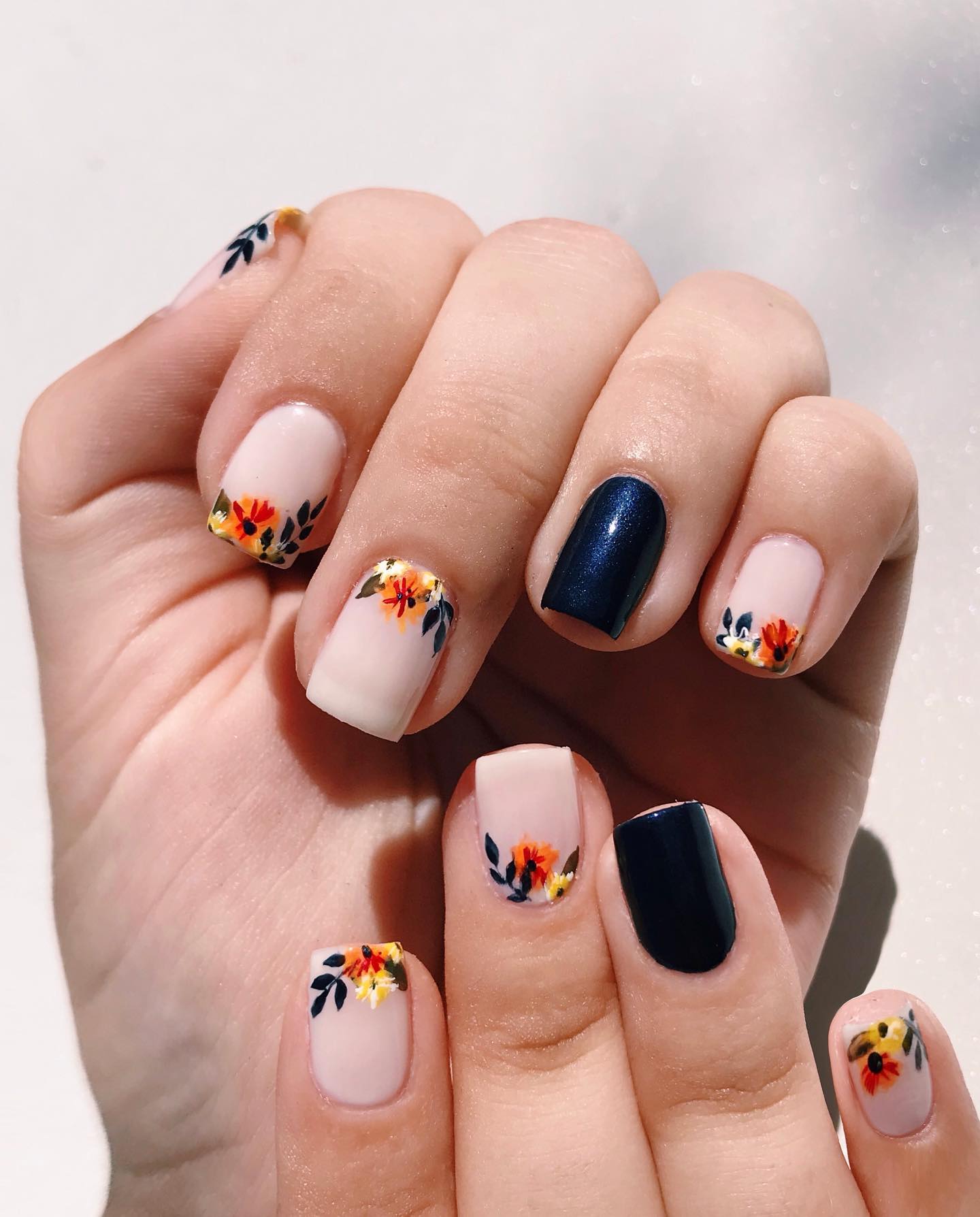 Square navy blue autumn nails with delicate floral nail art.