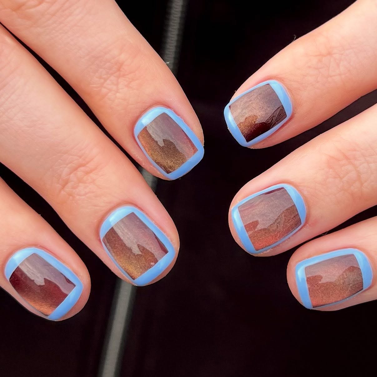 Abstract brown and pale blue autumn nails with graphic nail art.