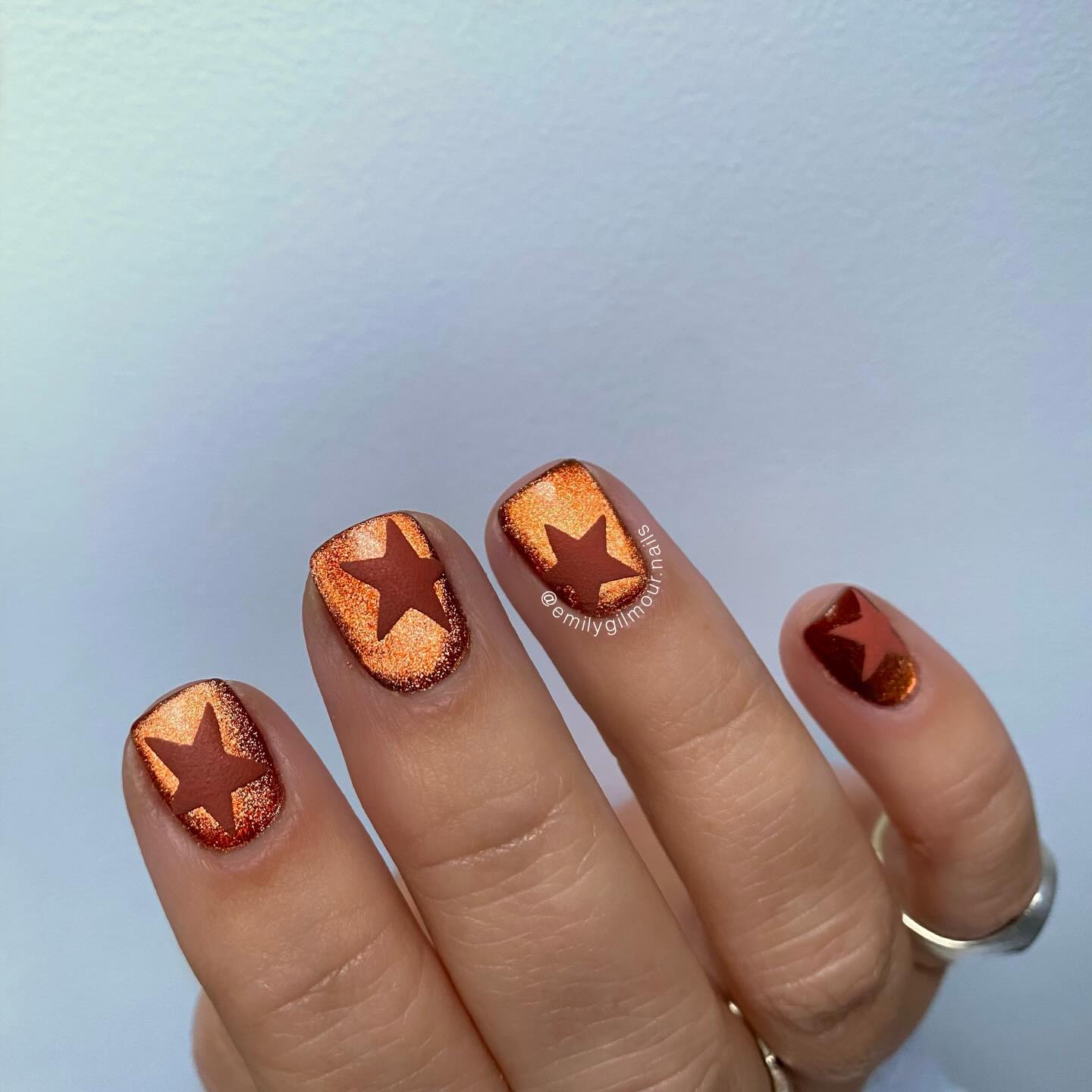 Copper autumn nails with delicate star nail art.