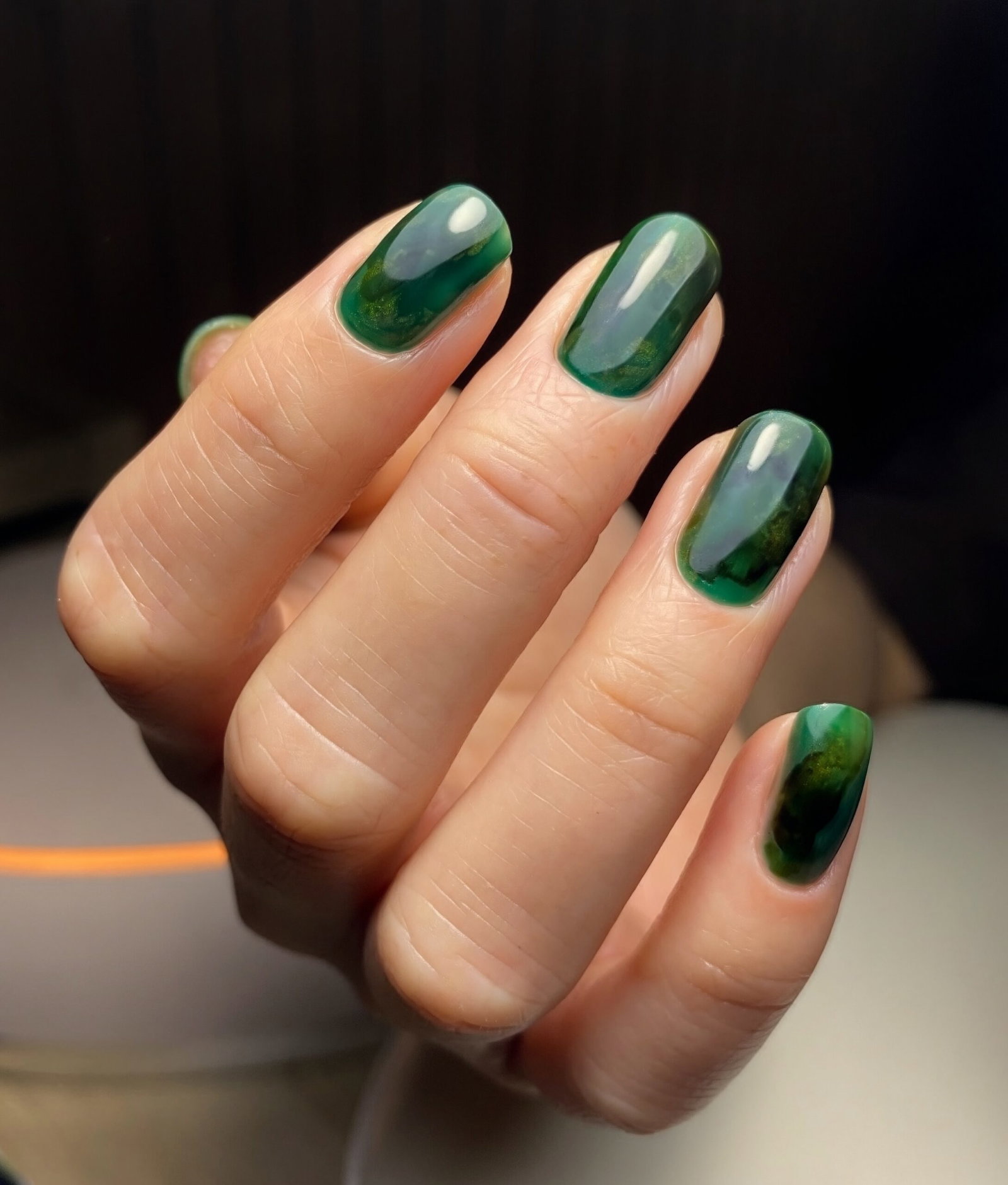 Green marble nails with swirling autumnal nail art.
