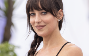 Dakota Johnson with a soft brunette fringe, loose face-framing strands and a low ponytail.