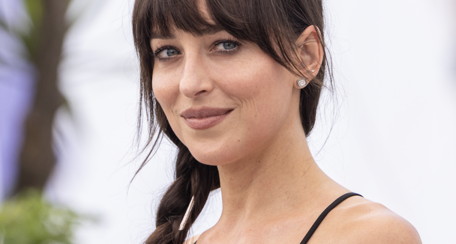 Dakota Johnson with a soft brunette fringe, loose face-framing strands and a low ponytail.