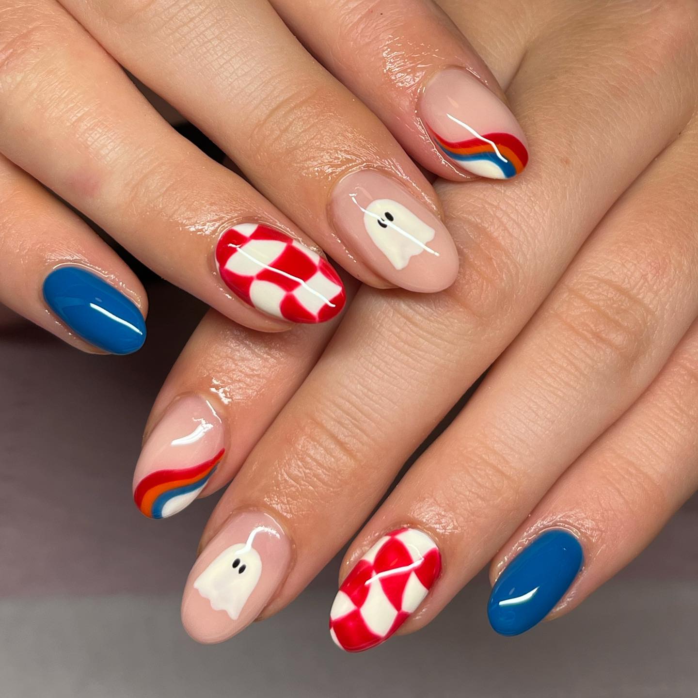 Red, white and blue Halloween manicure with checkerboard nail art, rainbow tips and white ghosts