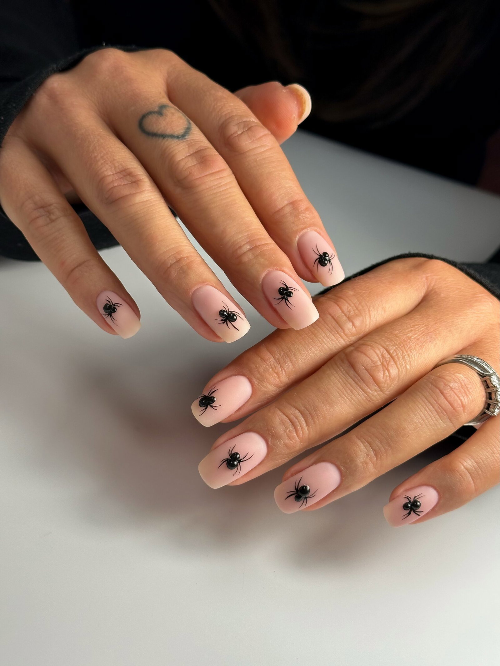 Nude pink square nails decorated with raised black 3D spiders for Halloween
