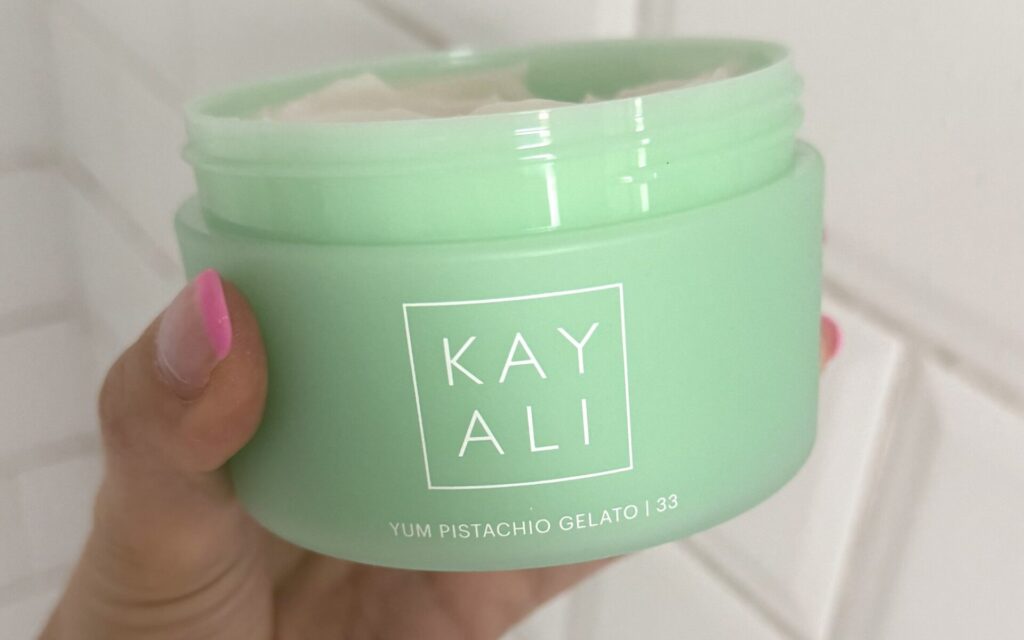 Kayali Yum Pistachio Gelato body cream held in hand during testing
