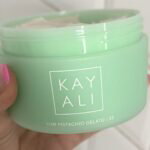 Kayali Yum Pistachio Gelato body cream held in hand during testing
