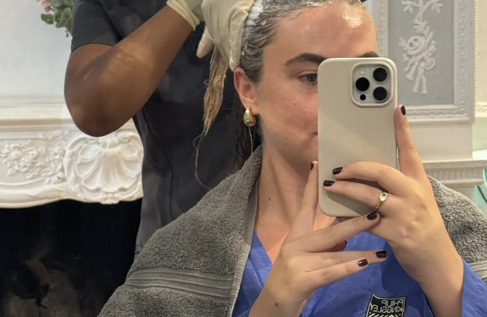 Close-up of a therapist massaging an exfoliating cream into the scalp during a Philip Kingsley hair treatment.