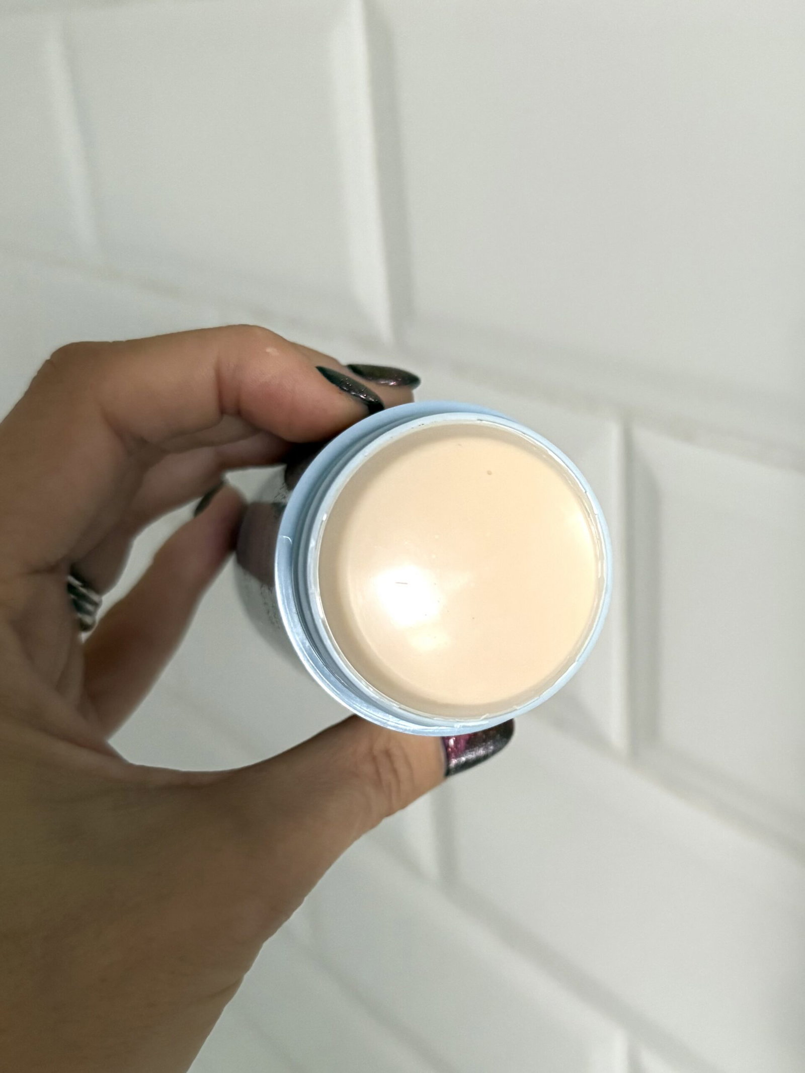 Close-up of the smooth, cream-coloured surface of Salt & Stone Lily & Yuzu deodorant inside its blue stick packaging.